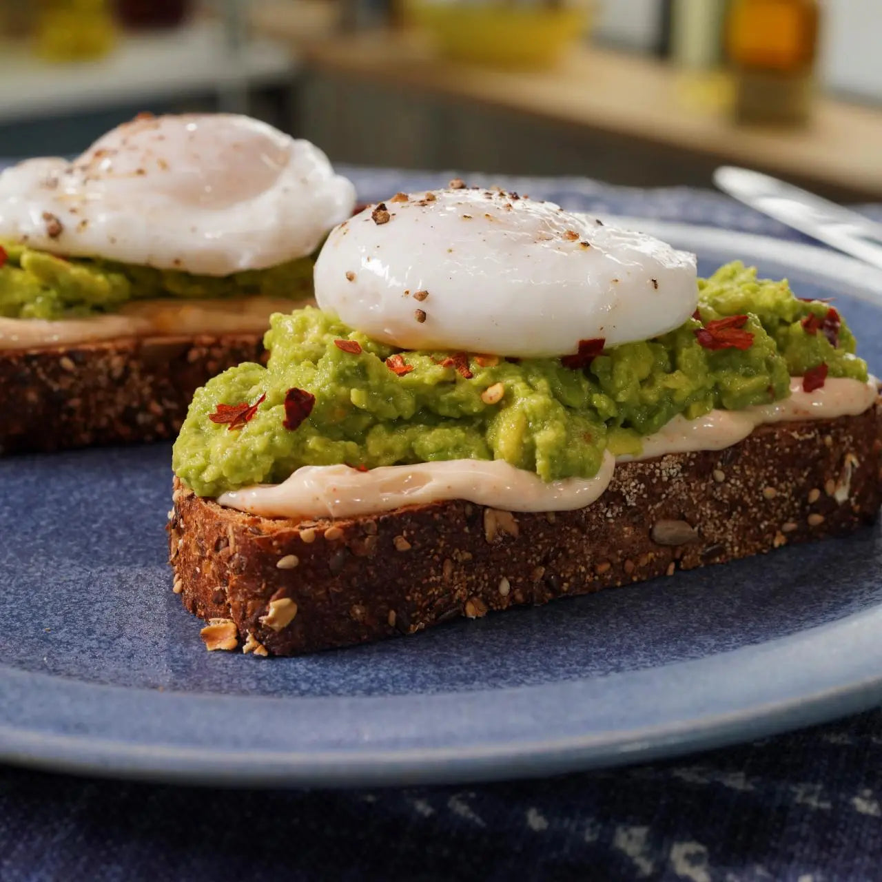 Avocado toast with poached eggs on a blue plate