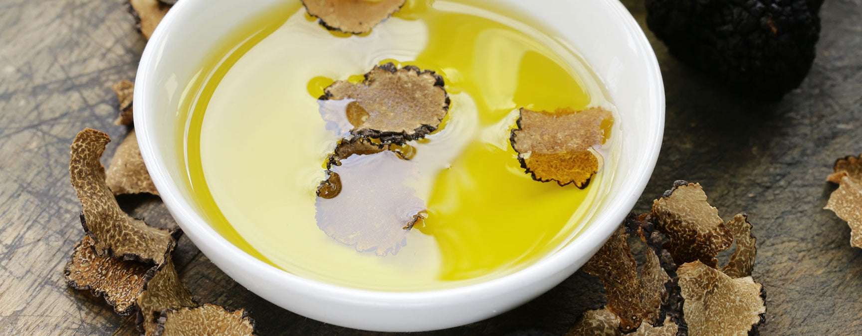 Professional chef finishing a dish with Milan Truffle extra virgin olive oil in a fine dining kitchen