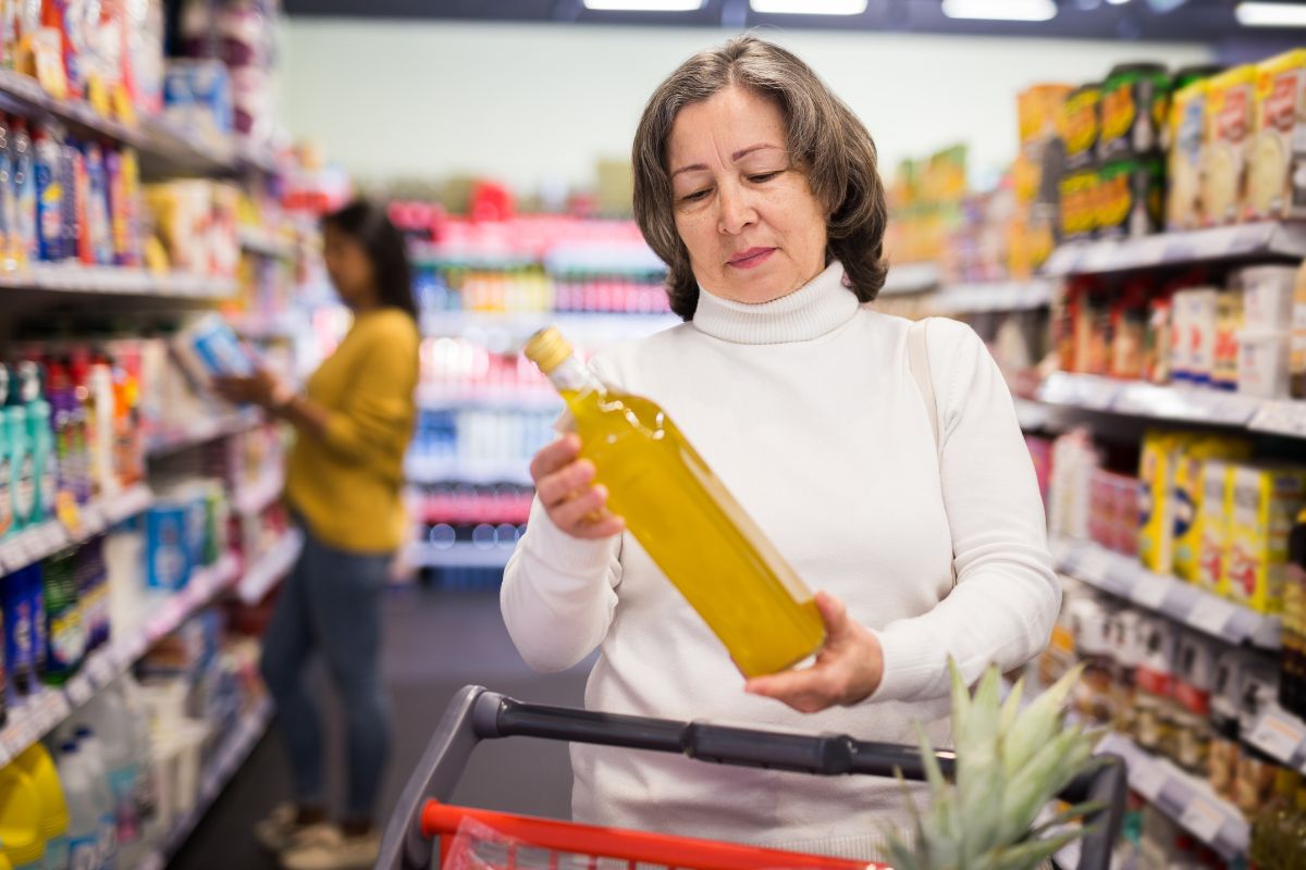 Shopper reading the country-of-origin information on an Italian olive oil label