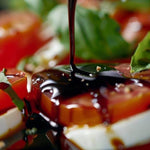 Balsamic vinegar drizzled over tomatoes, mozzarella and fresh basil.